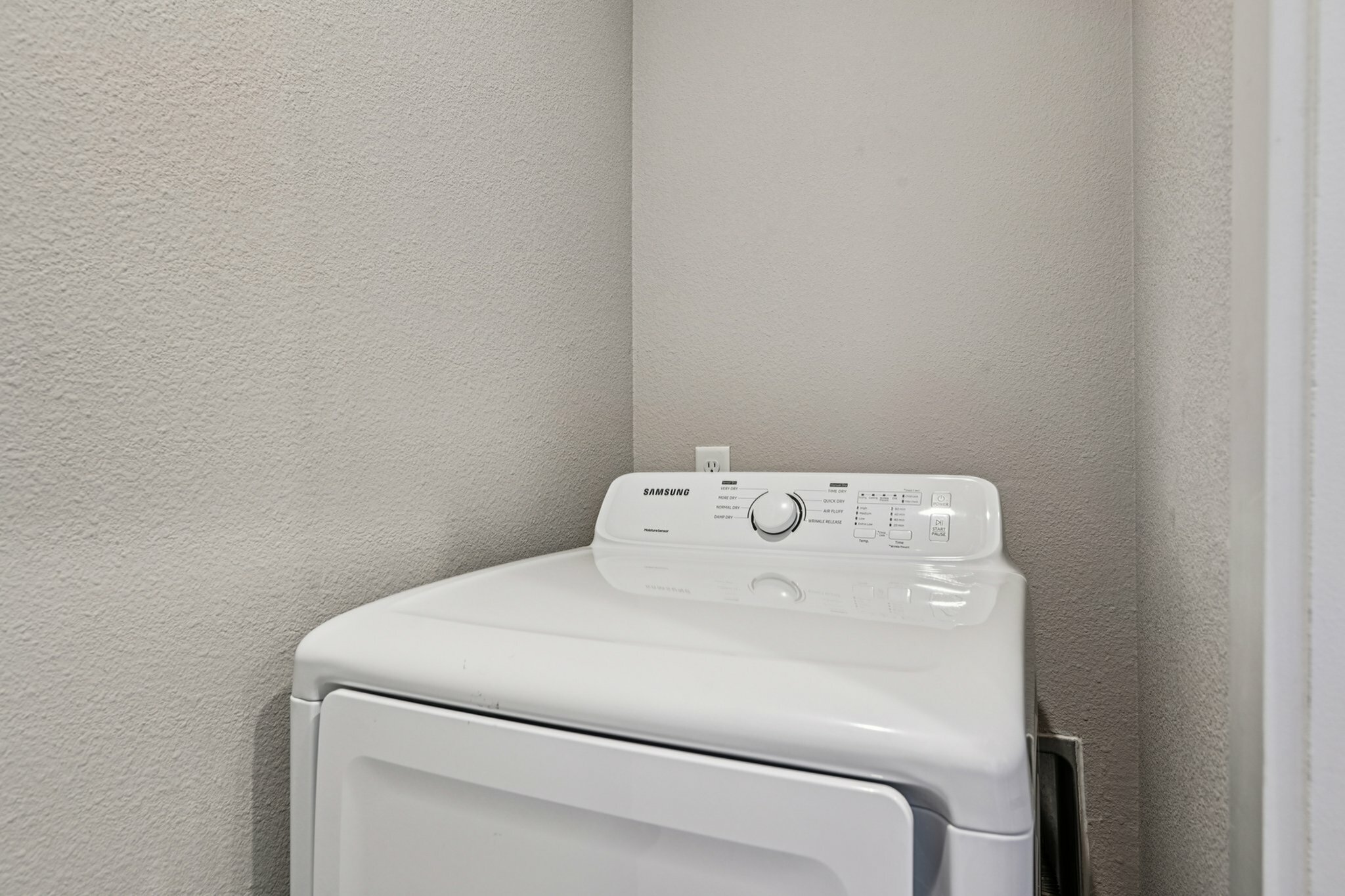 Modern laundry area showcasing a sleek Samsung washer against a neutral wall, adding convenience and style.