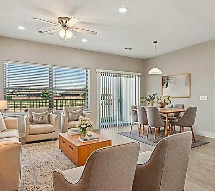 Bright and modern living and dining area with elegant furnishings, large windows, and cozy ambiance.
