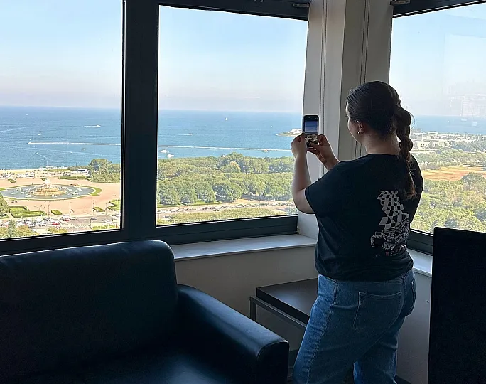 Stunning apartment view showcasing expansive windows overlooking a scenic waterfront and lush park, perfect for capturing breathtaking moments.