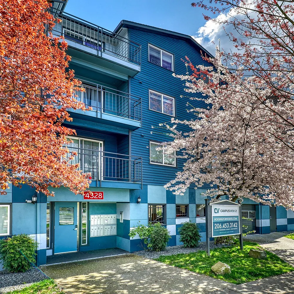 Charming blue residential building with vibrant autumn trees, offering a welcoming and colorful exterior.