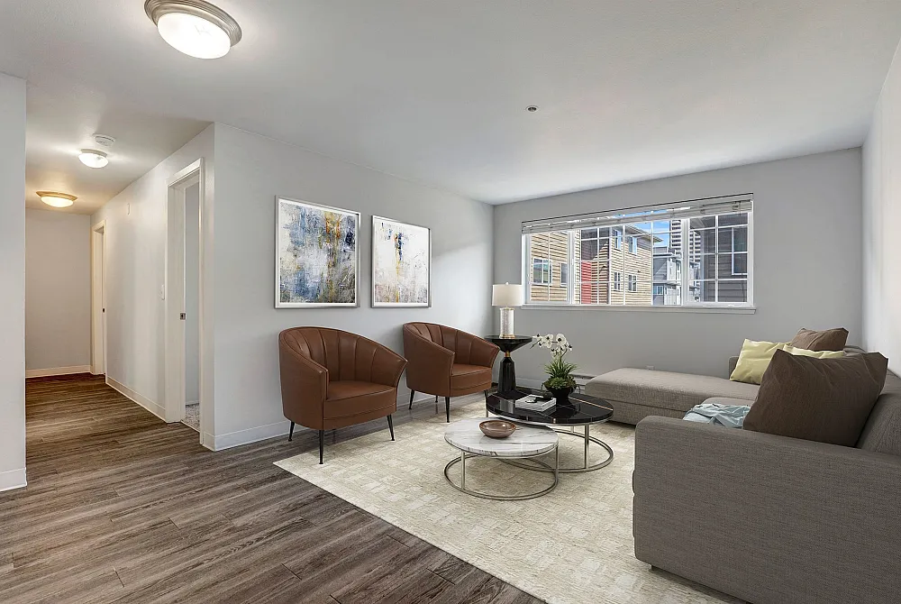 Bright and modern living room featuring elegant decor, plush seating, and large window with city views.