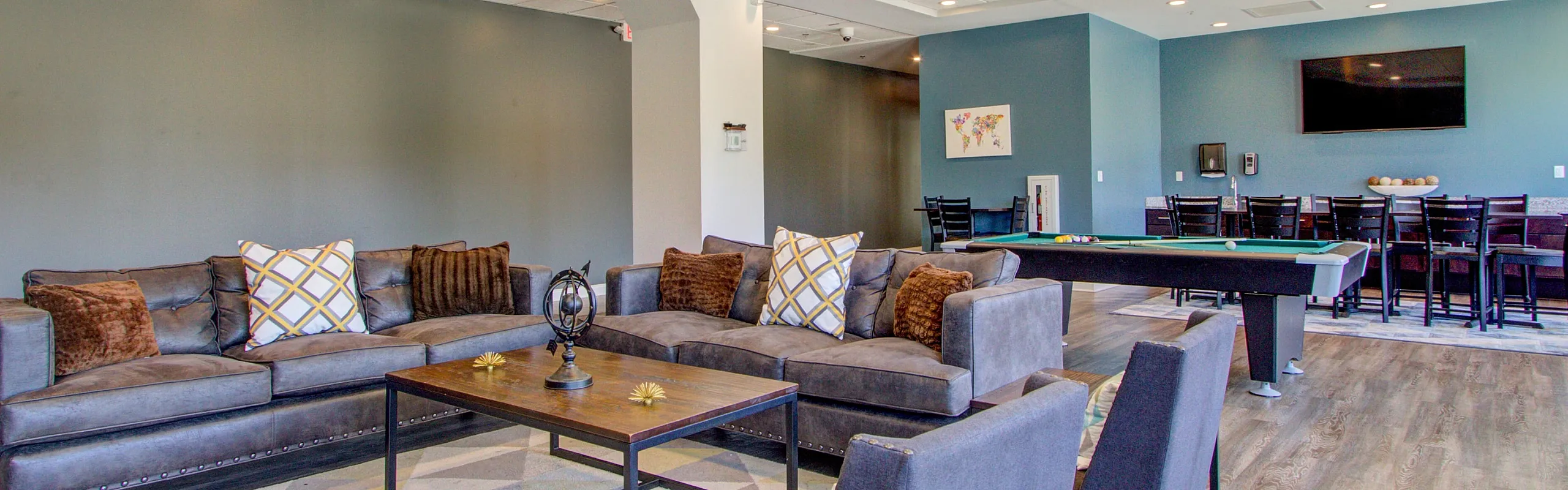 Contemporary communal lounge featuring plush seating, a stylish pool table, and a large flat-screen TV, perfect for relaxation and entertainment.