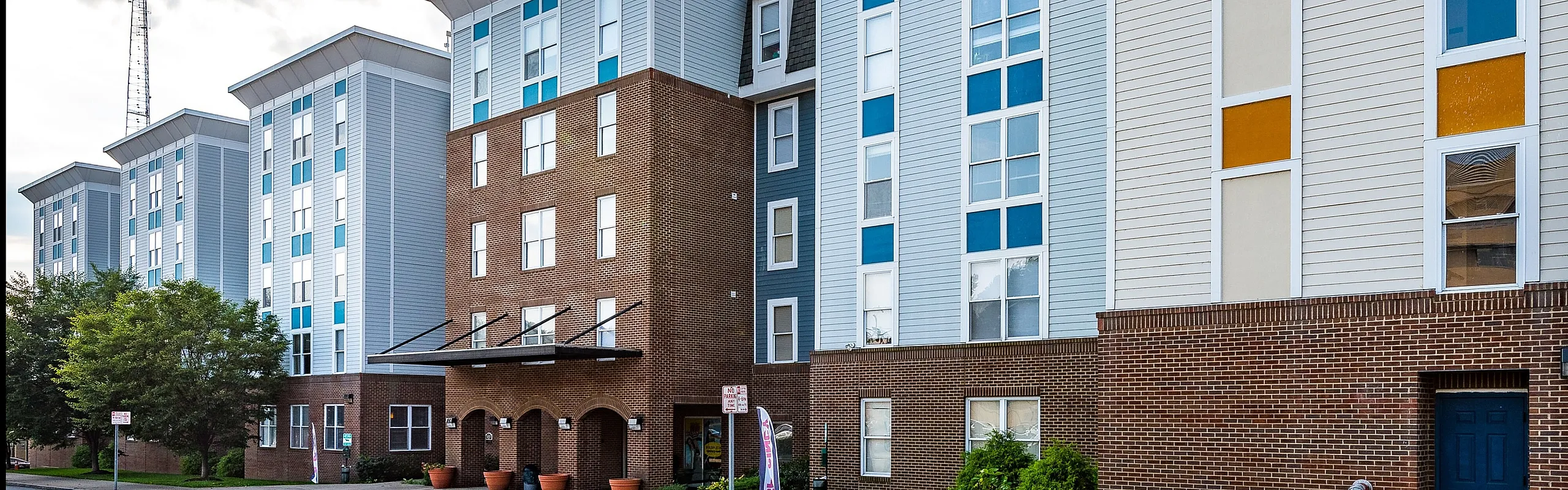 Chic urban apartment complex showcasing modern architecture with a charming mix of brick and siding, complete with tall windows for abundant natural light.