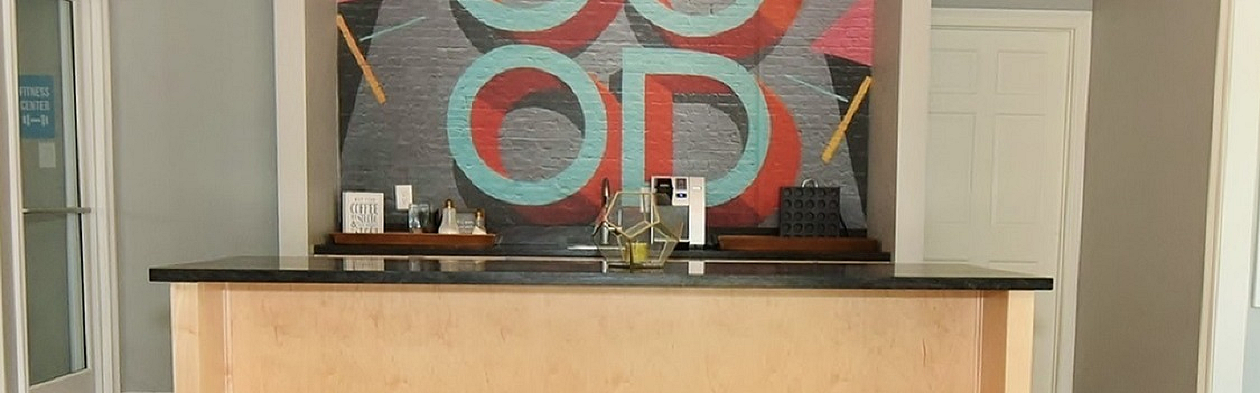 Chic lobby area with a modern light fixture and vibrant wall art, perfect for welcoming guests.