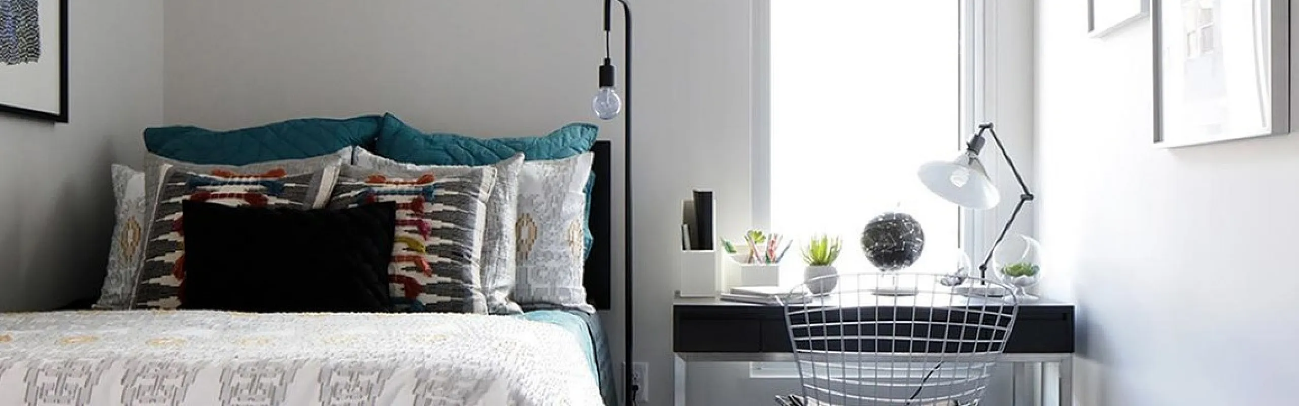 Modern bedroom with chic decor featuring a cozy bed, stylish desk, and sleek ceiling fan, offering a bright and inviting atmosphere.