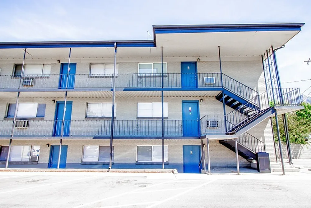 Modern apartment complex with vibrant blue accents, featuring multiple floors and spacious balconies.