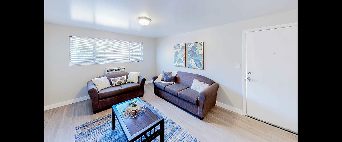 Bright and inviting living room with modern brown sofas, decorative pillows, and artistic wall decor, showcasing elegance in a cozy setting.