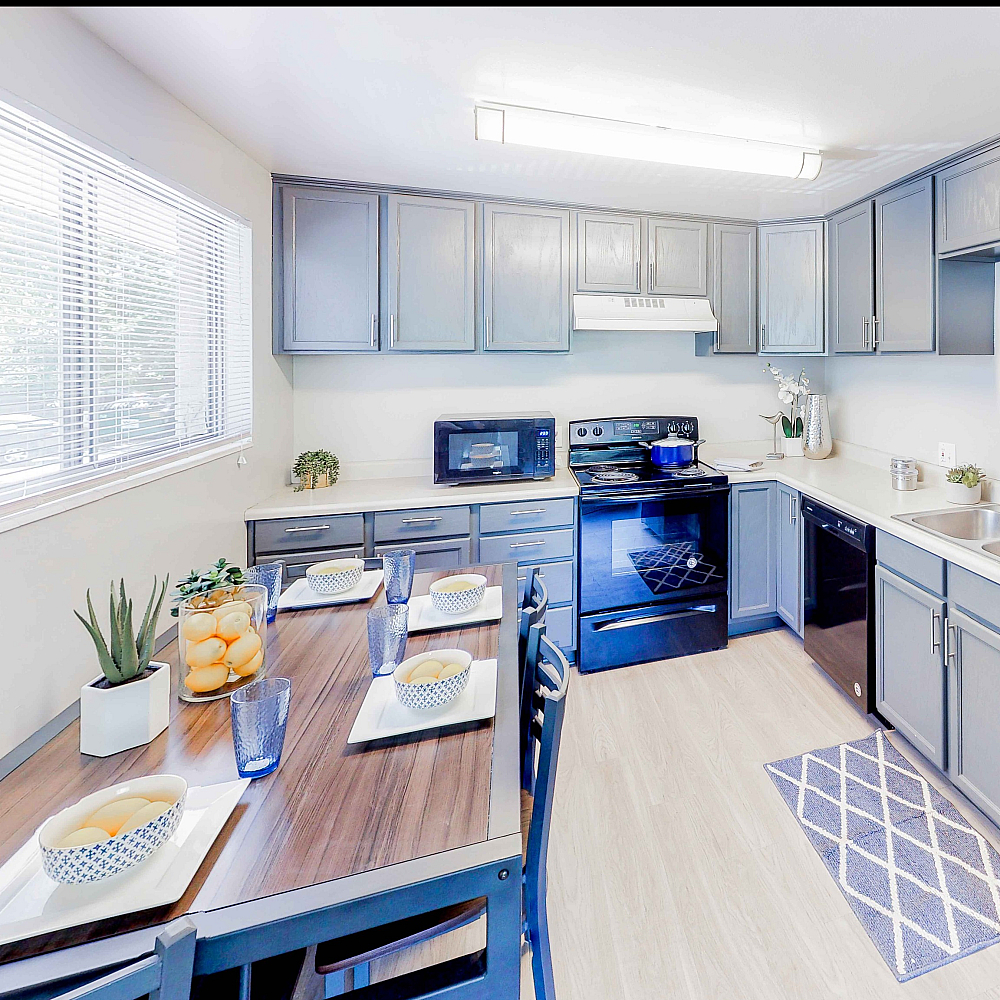 Bright and inviting kitchen with sleek gray cabinetry, modern appliances, and elegant dining setup.