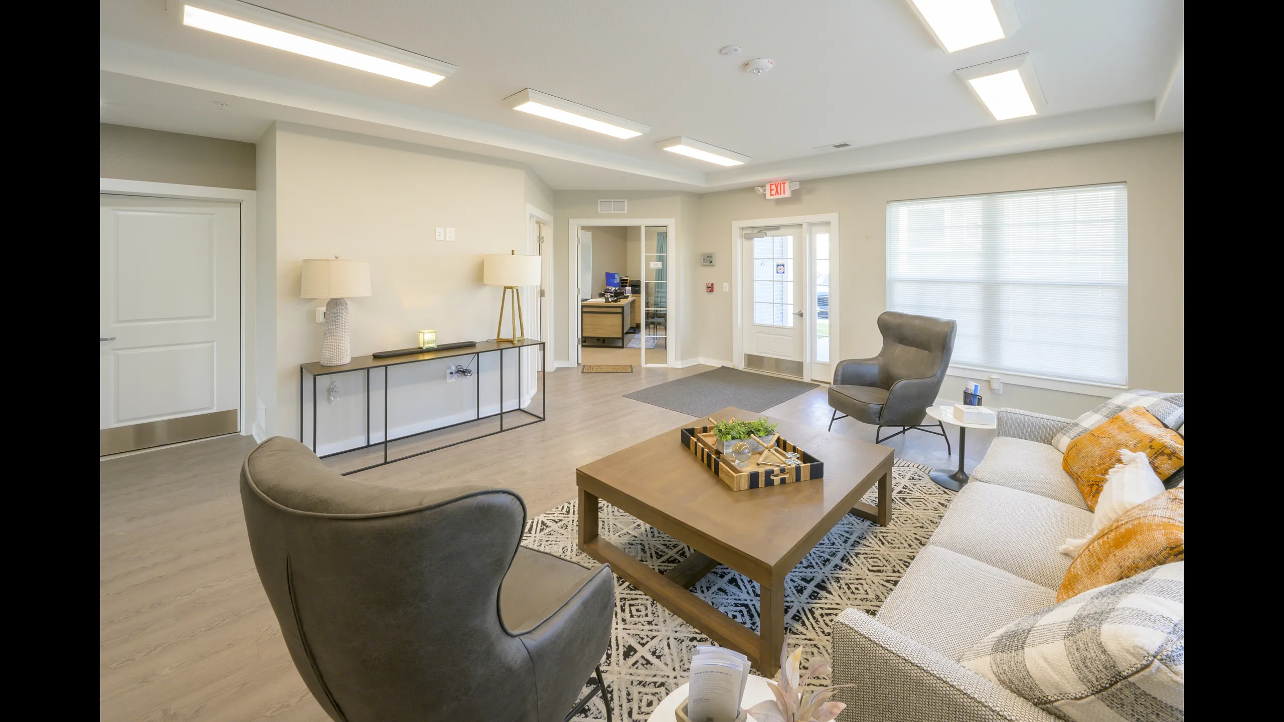 Inviting living area with modern furniture, stylish lighting, and natural light from large windows.