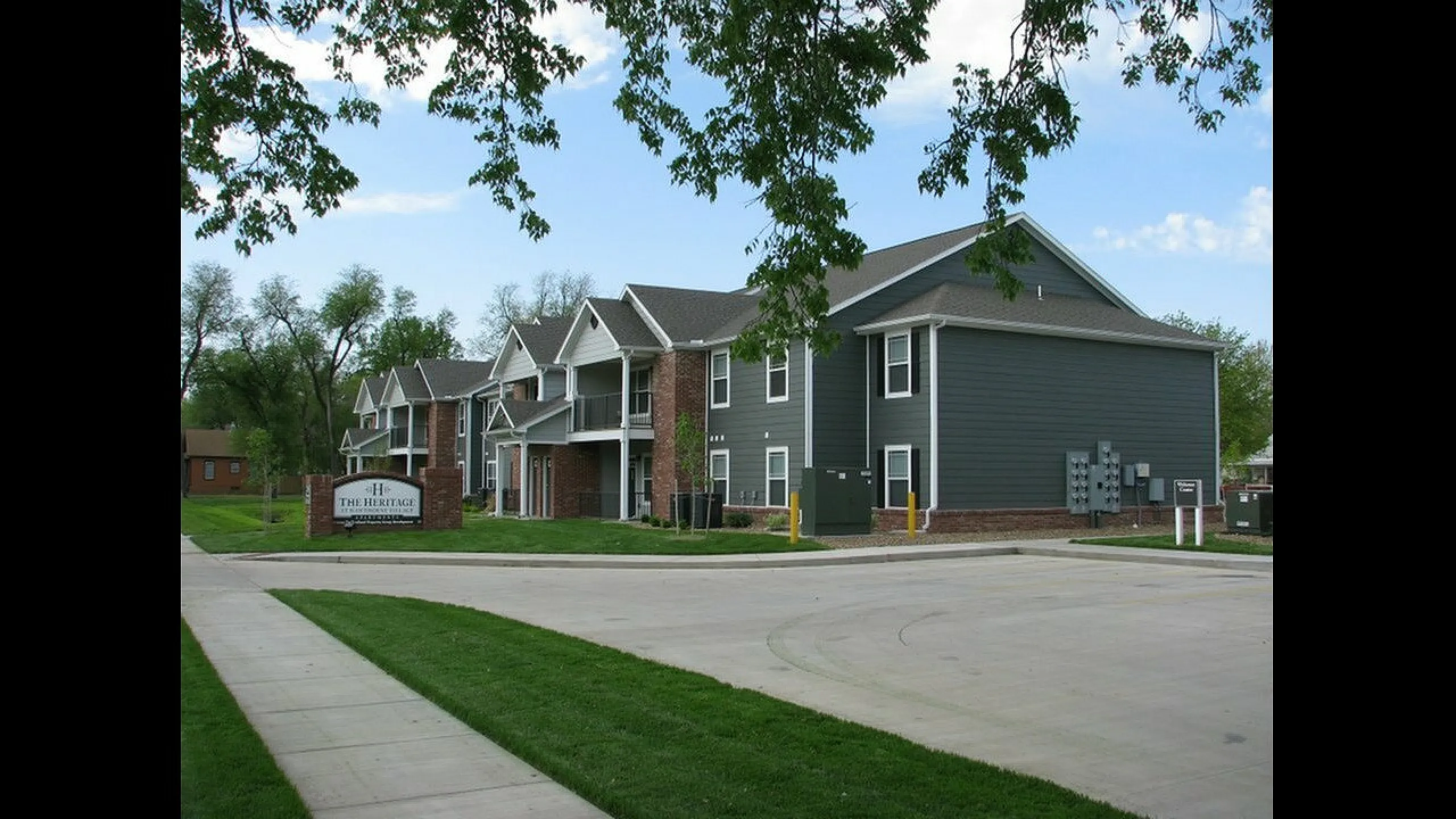 Charming modern apartment complex with classic architecture and lush green surroundings, perfect for a serene lifestyle.