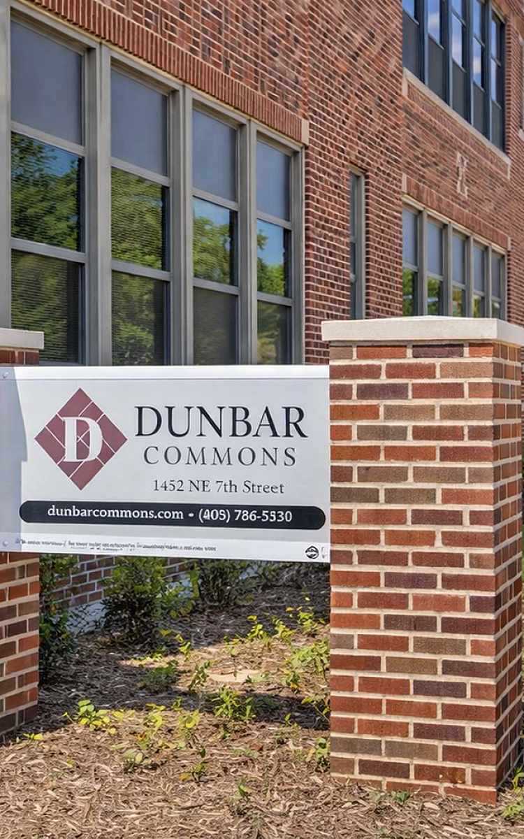Inviting view of Dunbar Commons with classic red brick architecture and lush green surroundings, emphasizing elegance and modern living.