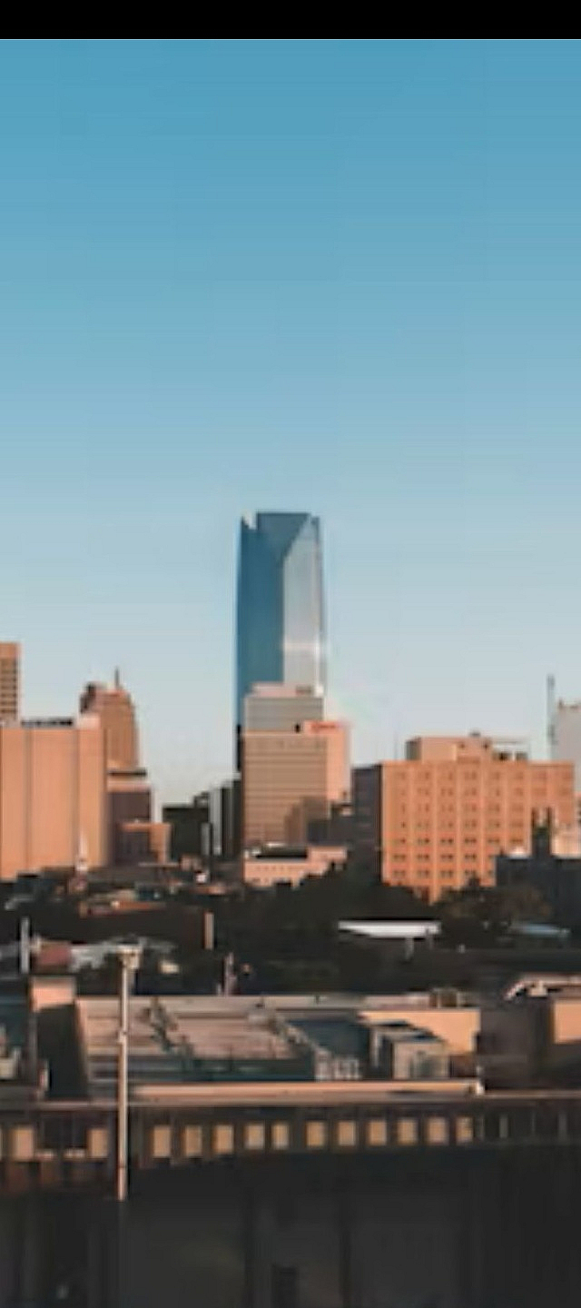 Dynamic city skyline under a clear blue sky showcasing a blend of modern skyscrapers and classic architecture.