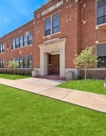 Charming red brick apartment building with well-maintained landscaping and inviting entrance.