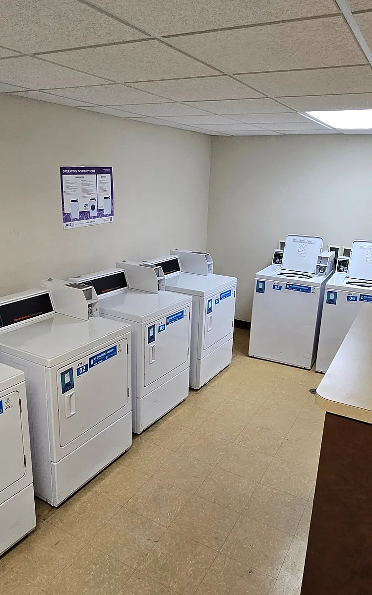 Bright and clean laundry room equipped with modern washing machines and dryers, offering convenience and efficiency.