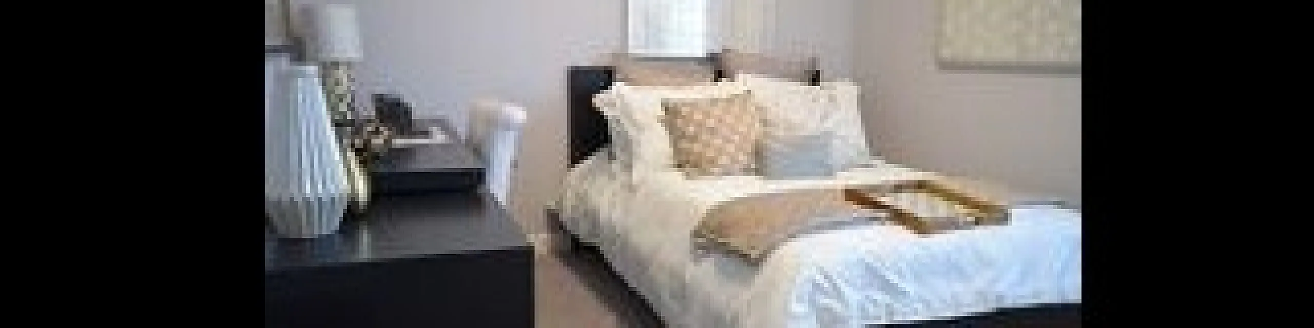 Elegant bedroom featuring a plush bed with cozy pillows, stylish decor, and a work desk; perfect blend of comfort and functionality.