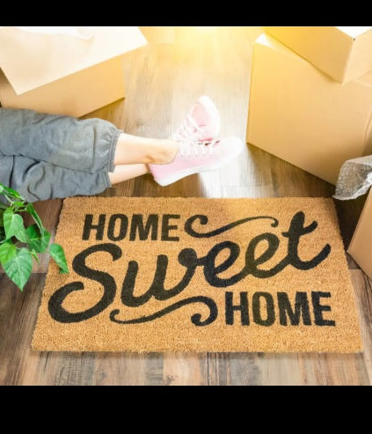 Welcoming home environment with a 'Home Sweet Home' doormat, surrounded by moving boxes and a touch of greenery.