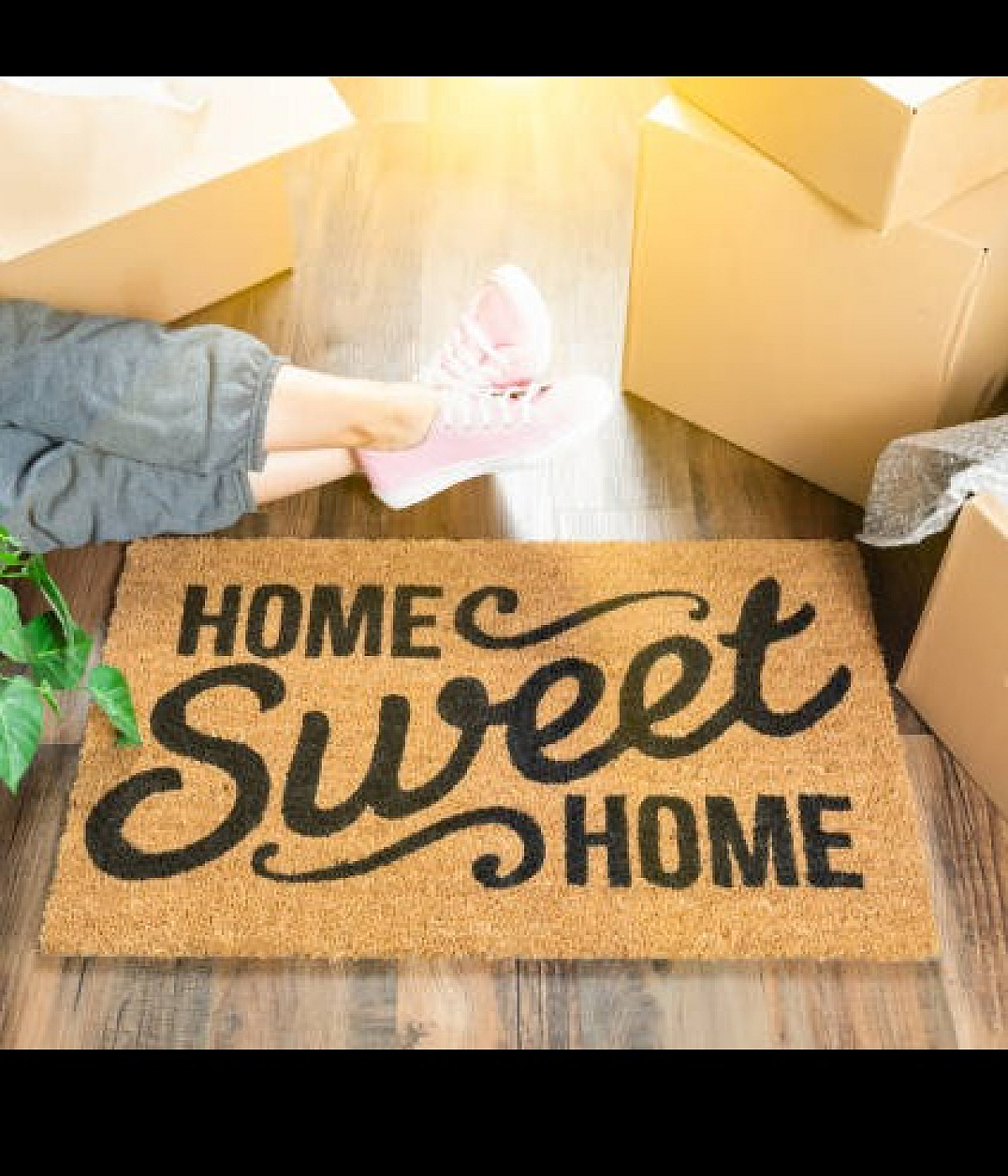 Welcoming scene with a cozy 'Home Sweet Home' doormat, surrounded by moving boxes and bright sunlight, symbolizing a fresh start in a new home.