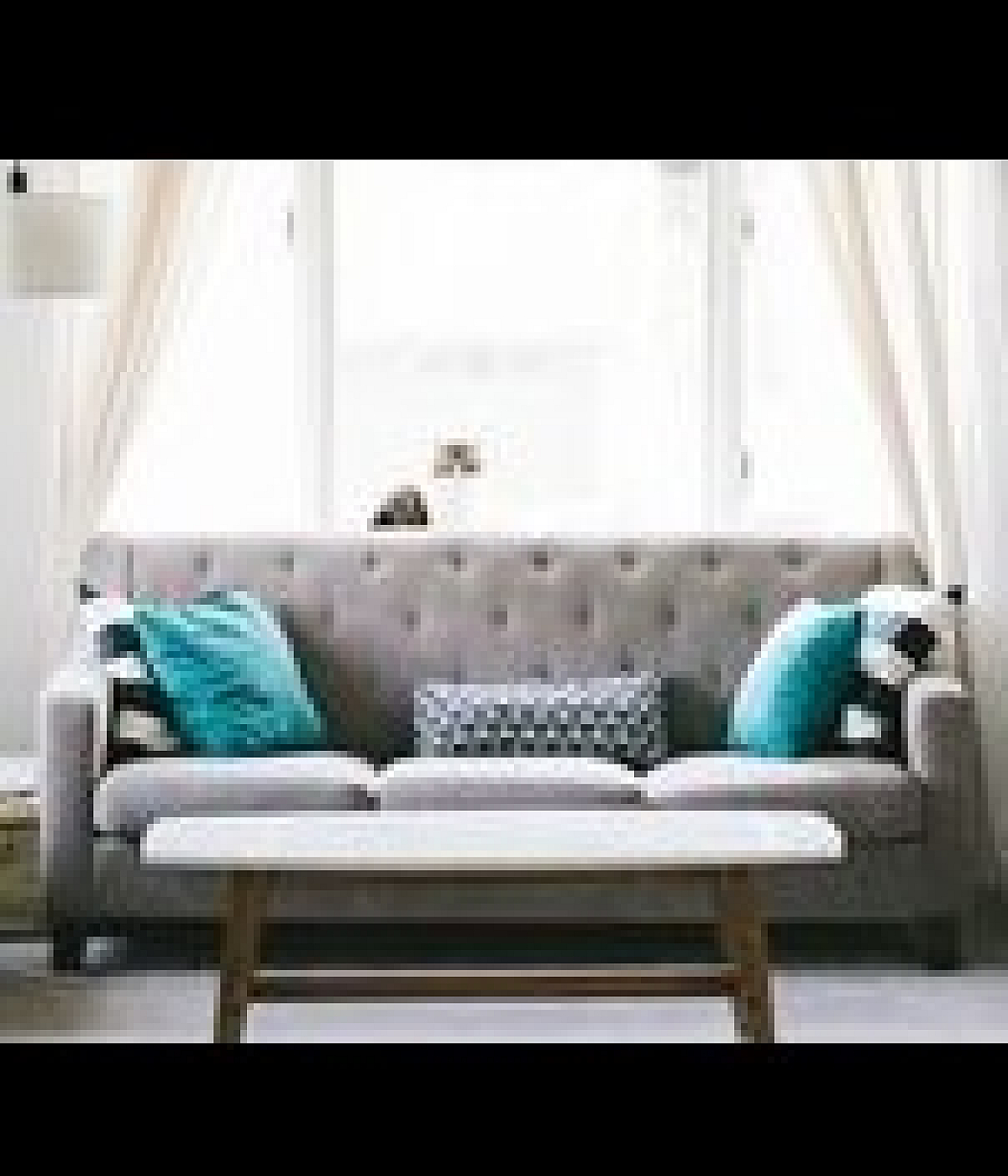 Charming living room with elegant gray sofa, vibrant teal cushions, and a cozy atmosphere.