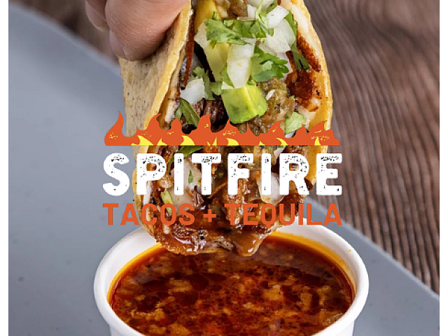 Mouthwatering taco dipped in rich birria sauce at Spitfire Tacos + Tequila, showcasing fresh ingredients and bold flavors.