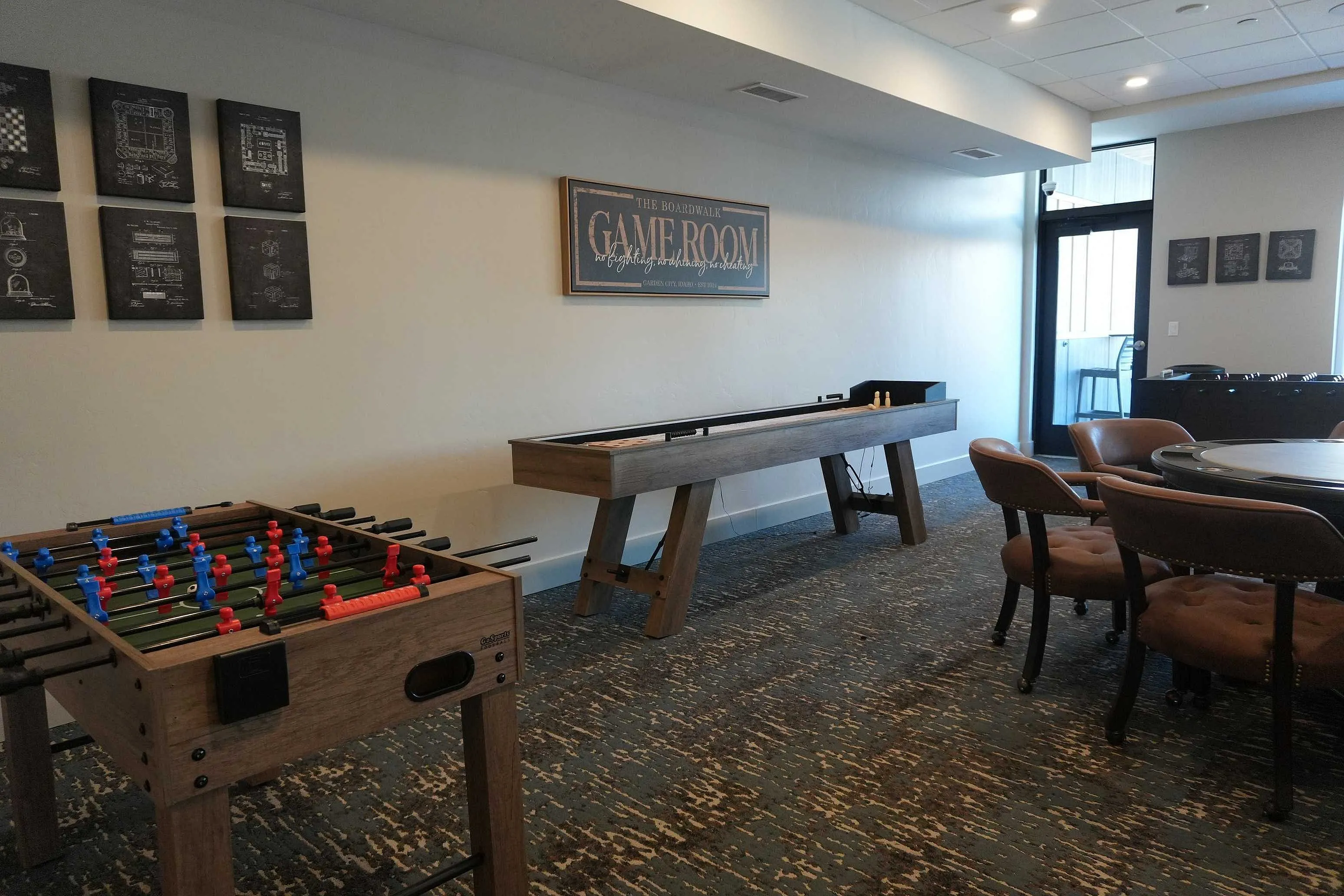 Chic and inviting game room with foosball and shuffleboard tables, modern decor, and plush seating, perfect for relaxation and entertainment.