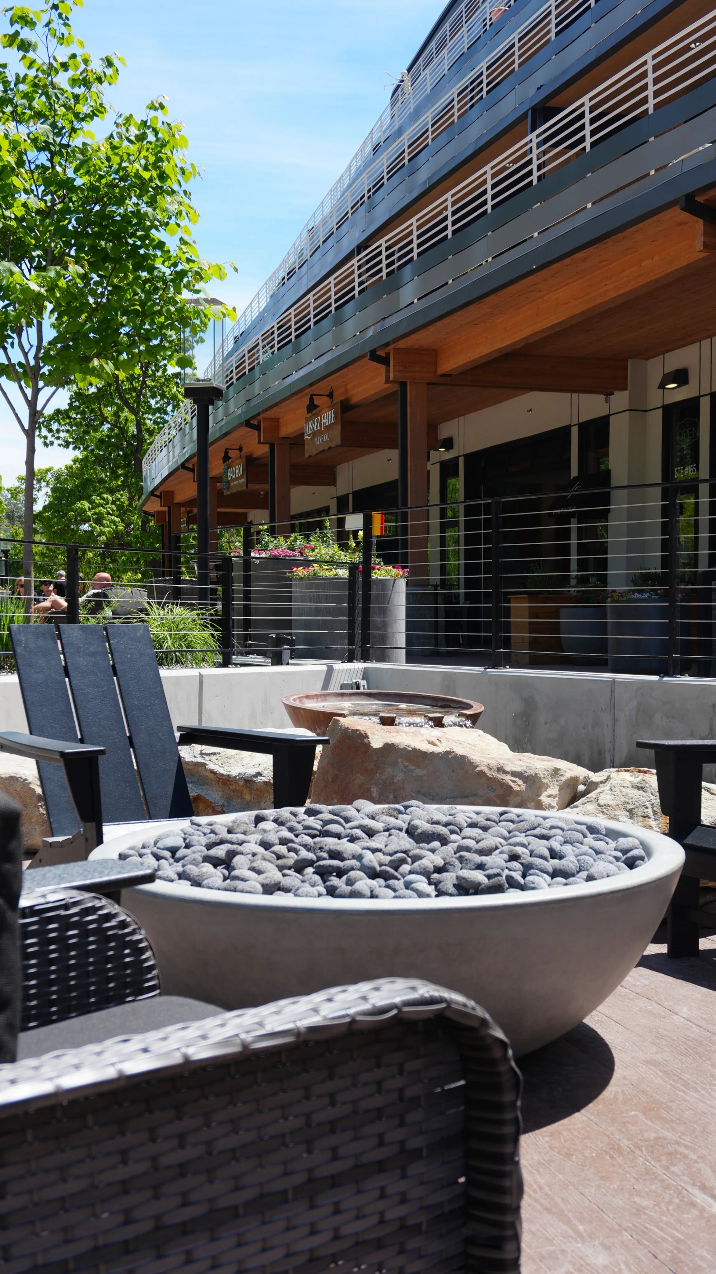 Chic outdoor seating area with modern architecture and lush greenery, perfect for relaxation and social gatherings.