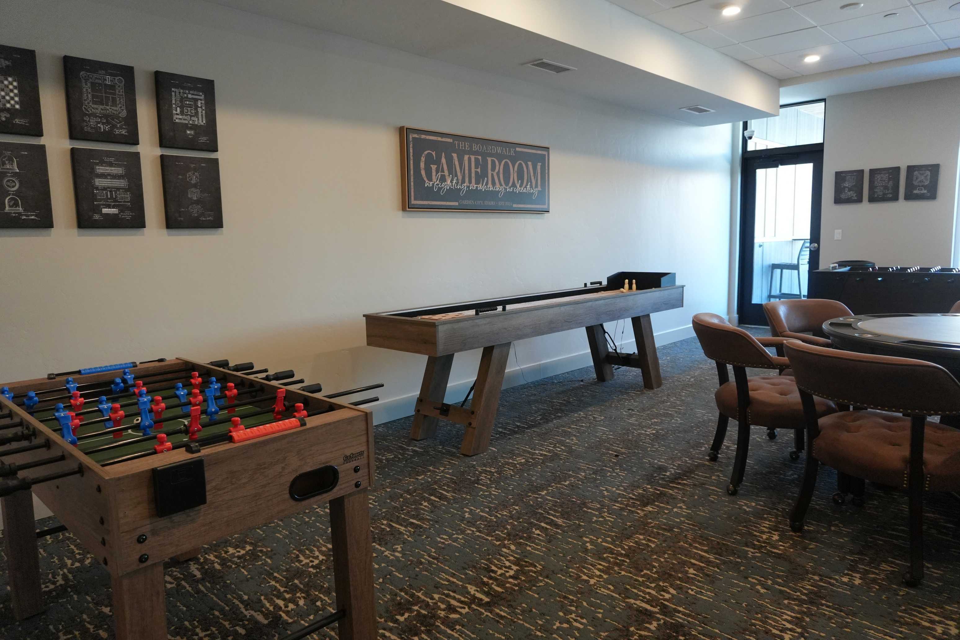 Inviting game room with stylish decor, featuring a foosball table, shuffleboard, and comfortable seating for social gatherings.