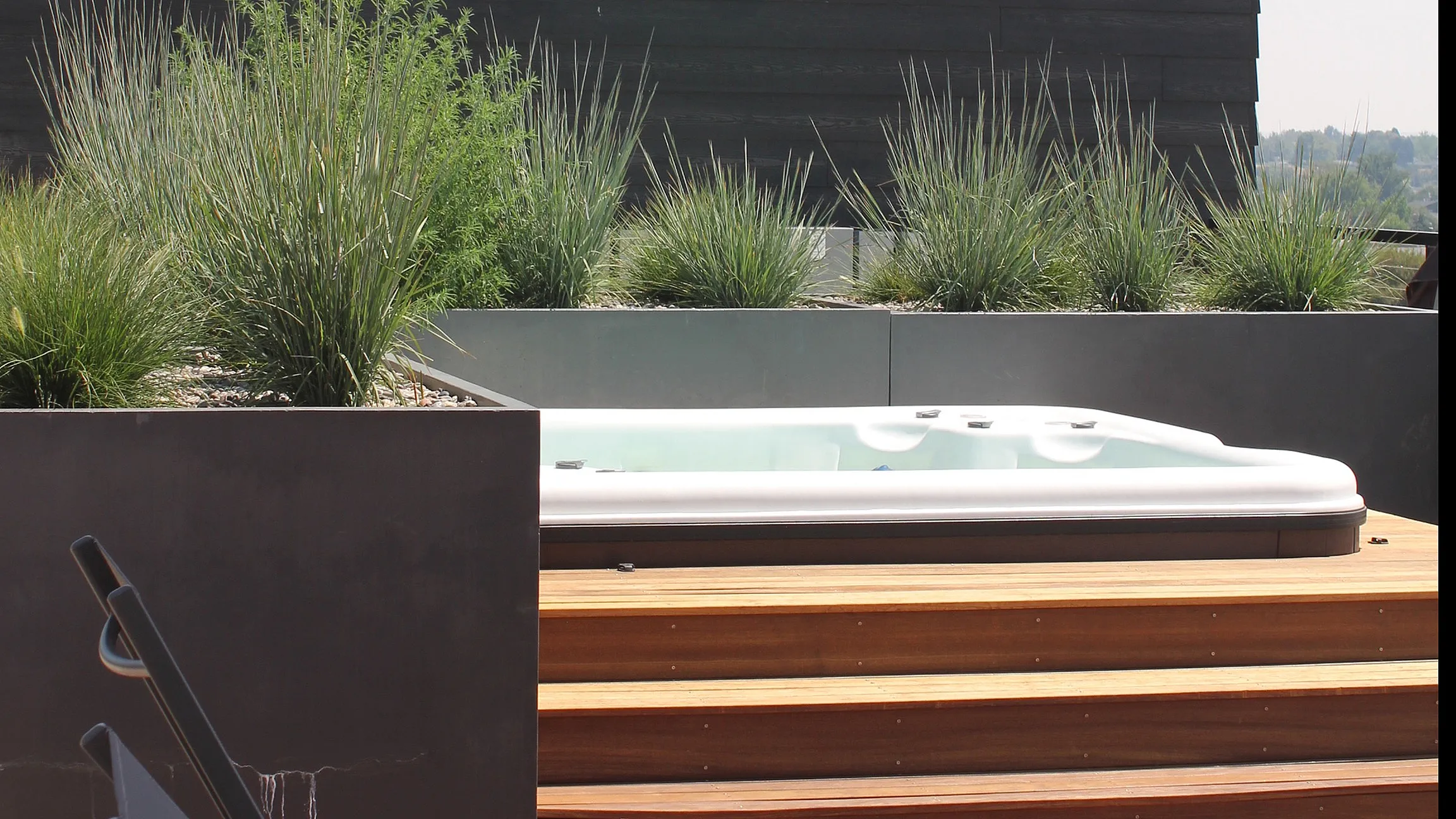 Elegant rooftop terrace with modern jacuzzi, stylish orange canopy, and lush greenery, perfect for relaxing and enjoying panoramic views.