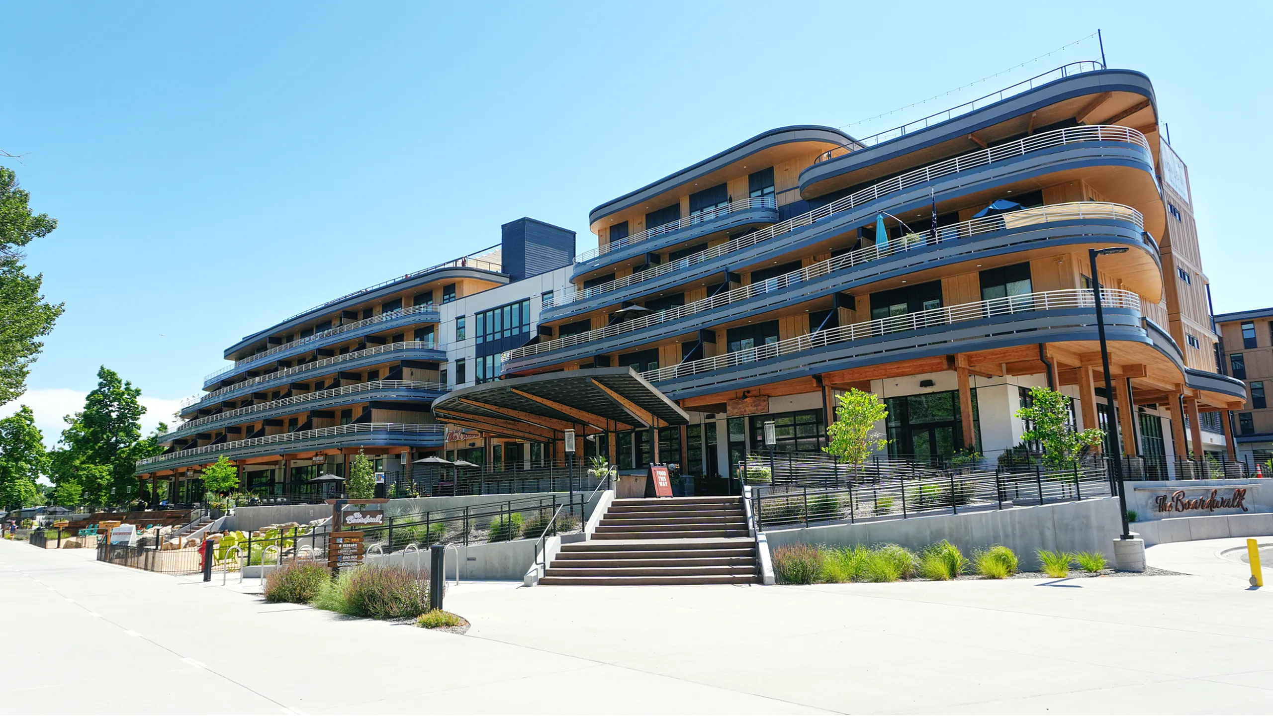 Contemporary multi-level apartment complex with sleek architecture, inviting balconies, and lush greenery in an urban setting.