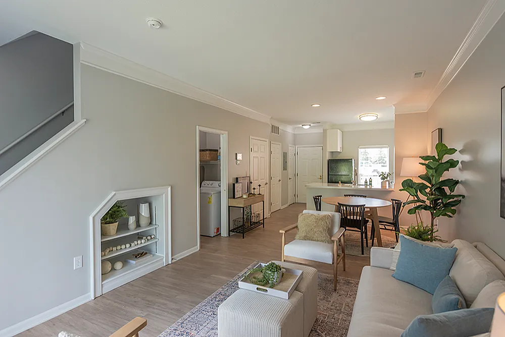Bright and inviting living space with modern decor, featuring an open kitchen, cozy seating area, and stylish dining setup.