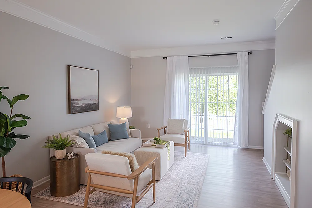 Bright and inviting living room with cozy seating, elegant decor, and large windows for natural light, perfect for relaxation.