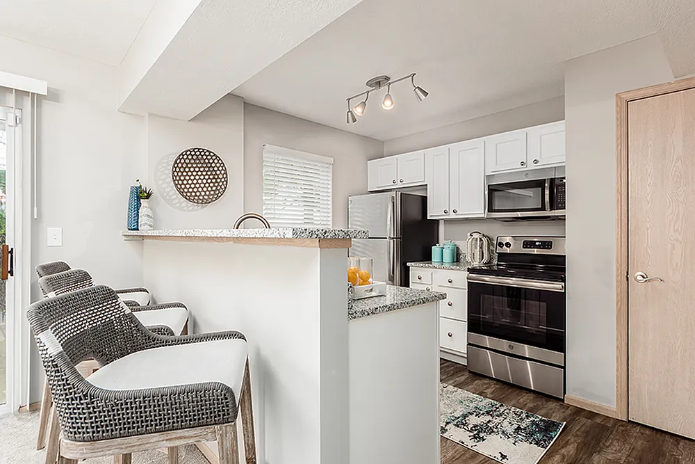 Bright and modern kitchen with sleek appliances and stylish breakfast bar seating, perfect for entertaining.