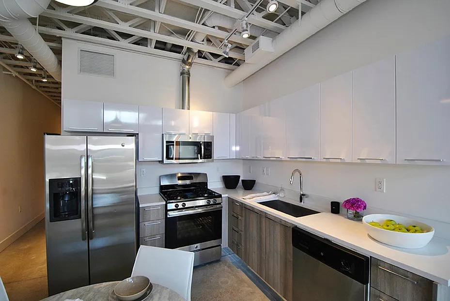 Contemporary kitchen featuring sleek stainless steel appliances, modern cabinetry, and stylish open shelving in a bright, spacious layout.