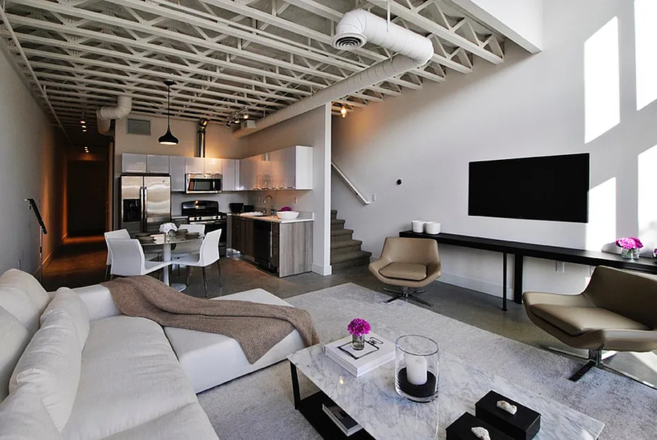 Modern loft-style living area with sleek open-concept design, featuring a comfortable lounge space, elegant kitchen, and dining area with chic decor.