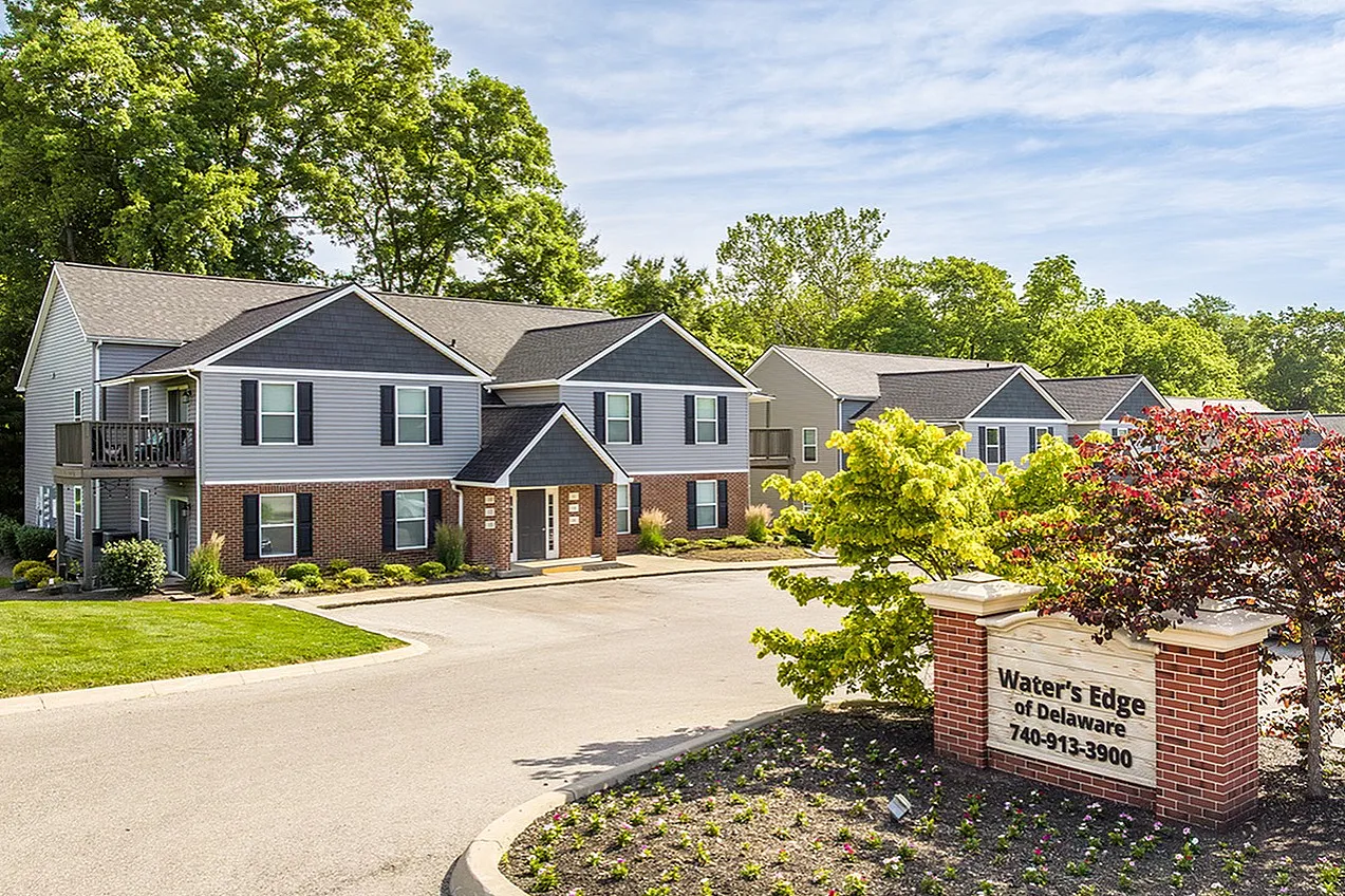 Charming apartment complex nestled in lush greenery, showcasing spacious two-story units at Water's Edge of Delaware.