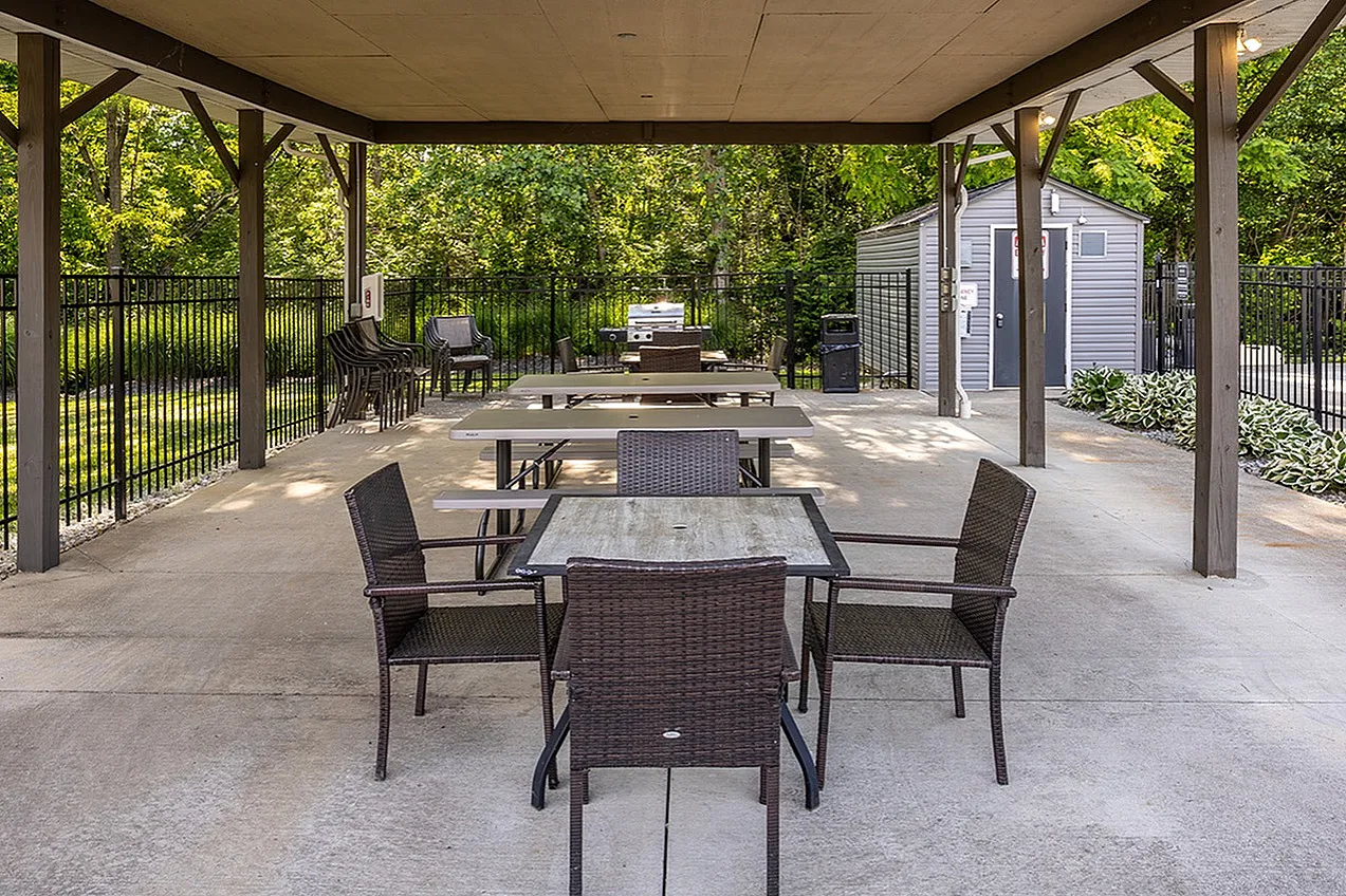 Inviting outdoor pavilion with stylish seating and lush green surroundings, perfect for gatherings and relaxation.