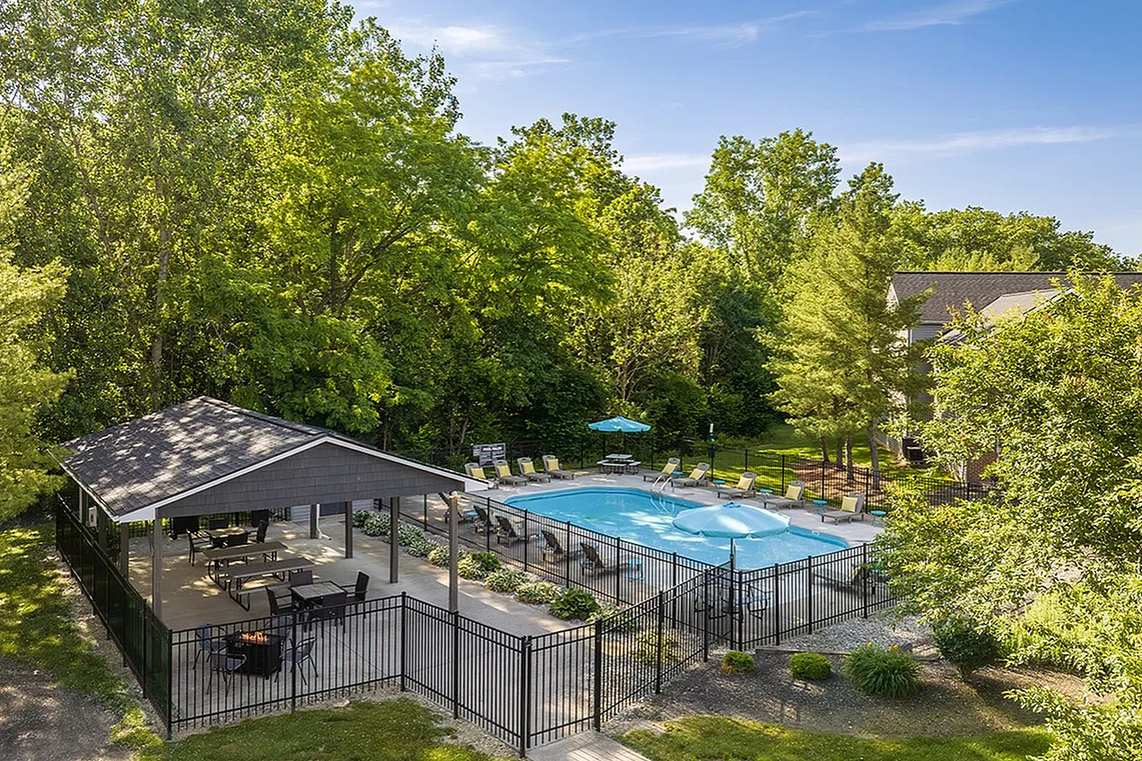 Inviting outdoor pool surrounded by lush greenery and cozy seating, ideal for relaxing in a serene setting.
