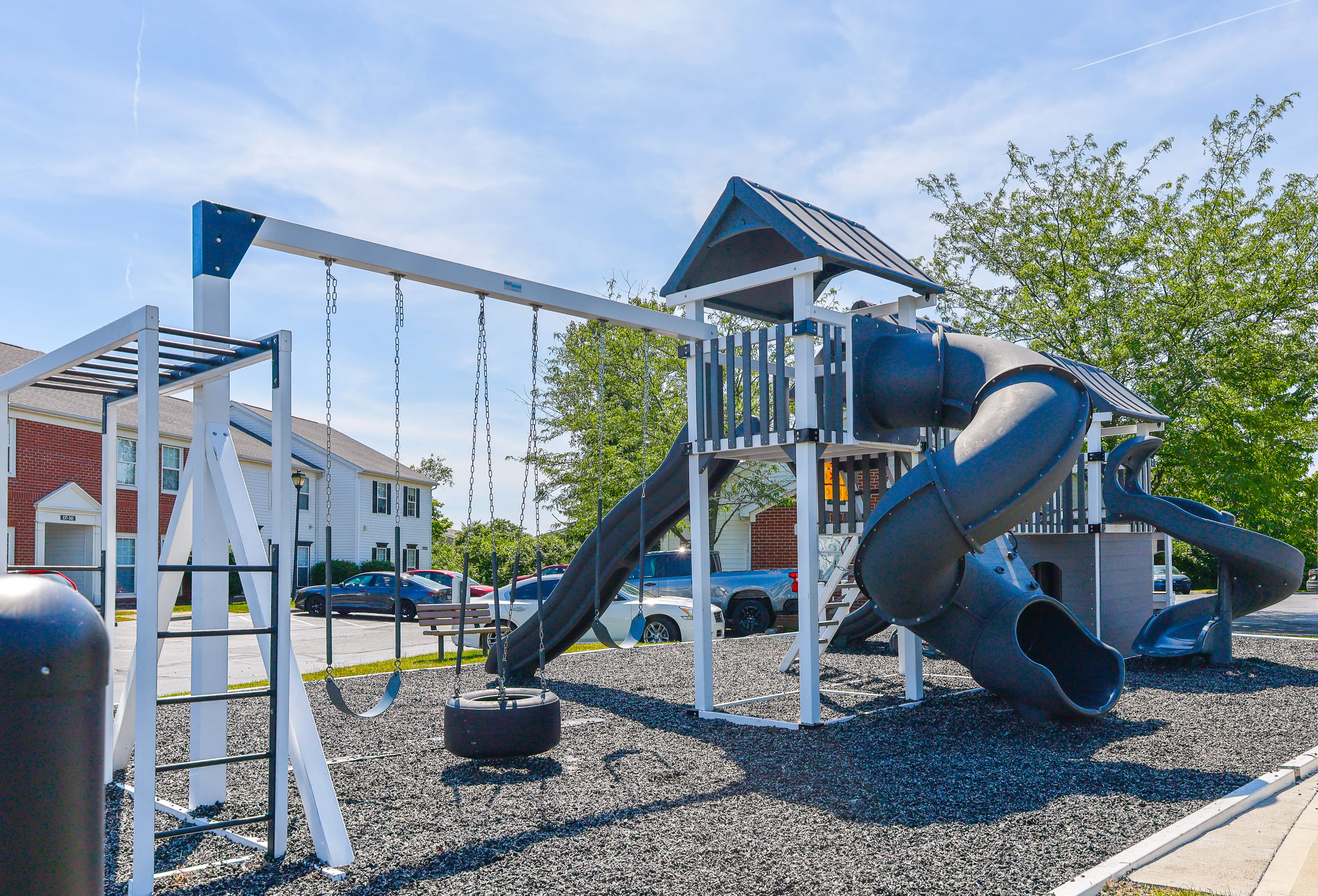 Inviting playground with swings and slides surrounded by charming residential buildings, perfect for family living.