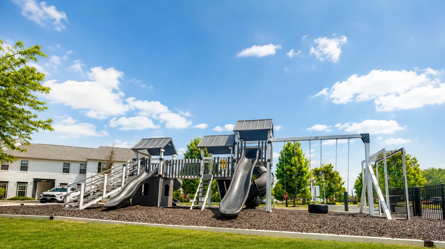 Bright and inviting outdoor playground featuring modern slides, swings, and a climbing structure, set against a vibrant blue sky.