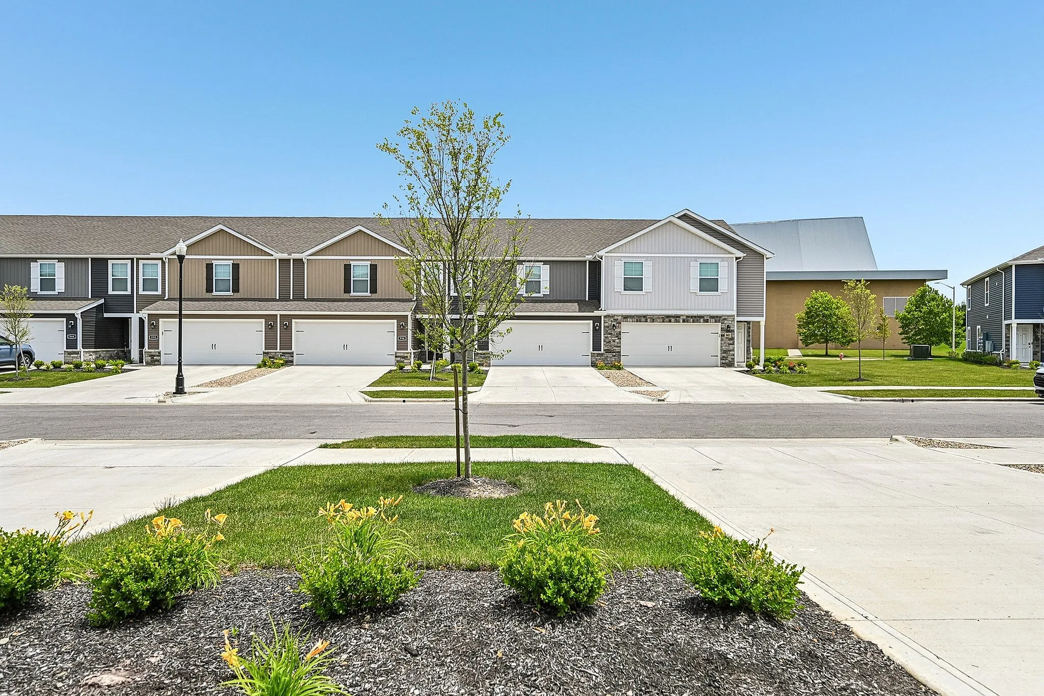 Charming suburban townhouse complex with beautiful landscaping and spacious driveways, ideal for modern family living.