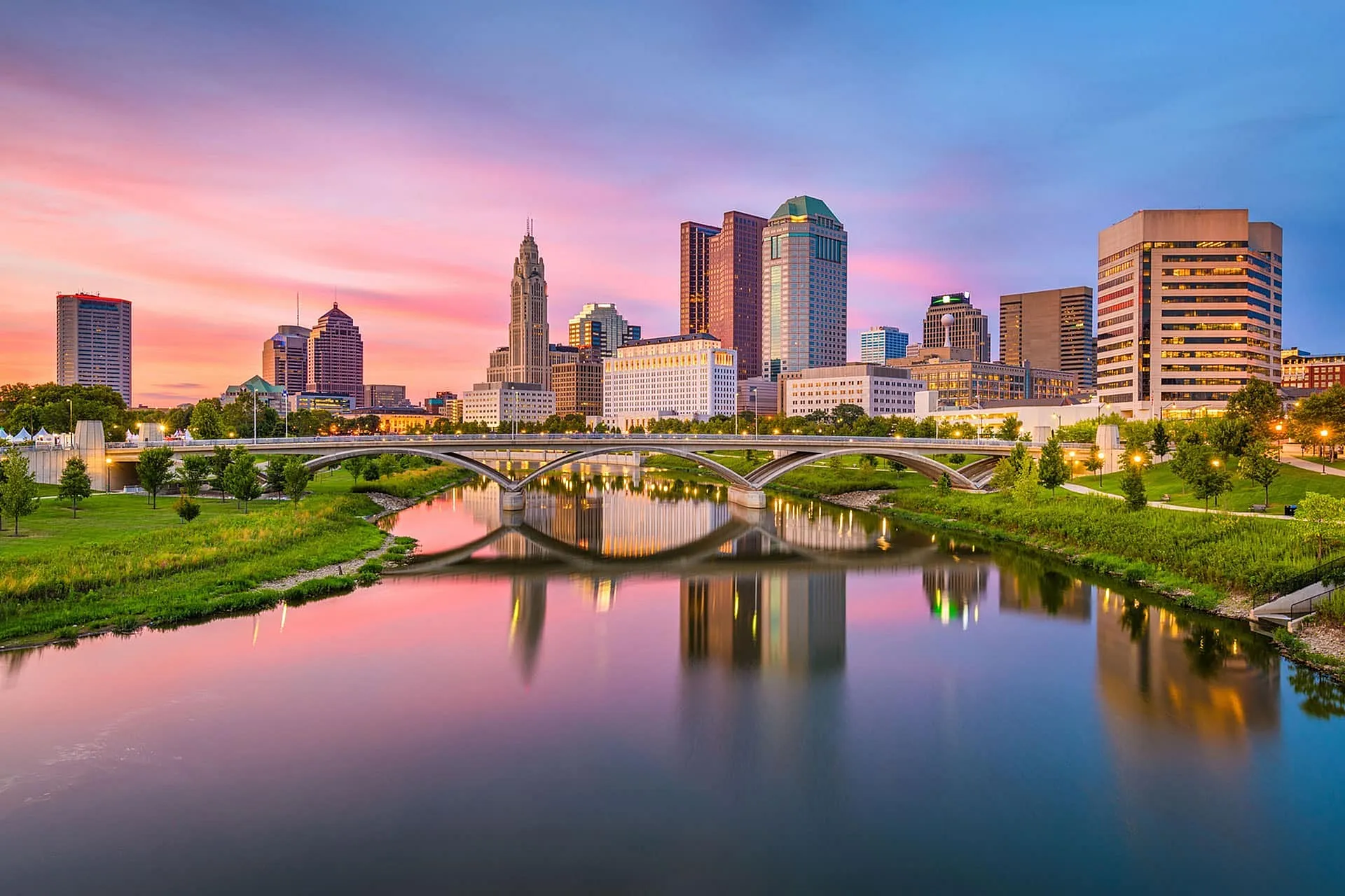 Breathtaking waterfront cityscape showcasing modern architecture at sunset, reflecting vibrant colors on the river.