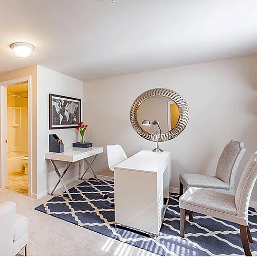 Chic home office space featuring modern decor, a stylish desk area, elegant seating, and vibrant wall art, perfect for productivity and comfort.