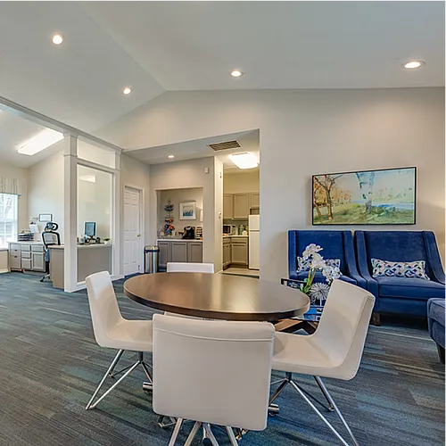 Modern open-concept office space with sleek furniture, vibrant artwork, and ample natural light.