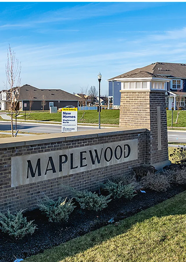 Charming Maplewood neighborhood with new homes, featuring modern architecture and lush landscaping under a clear blue sky.