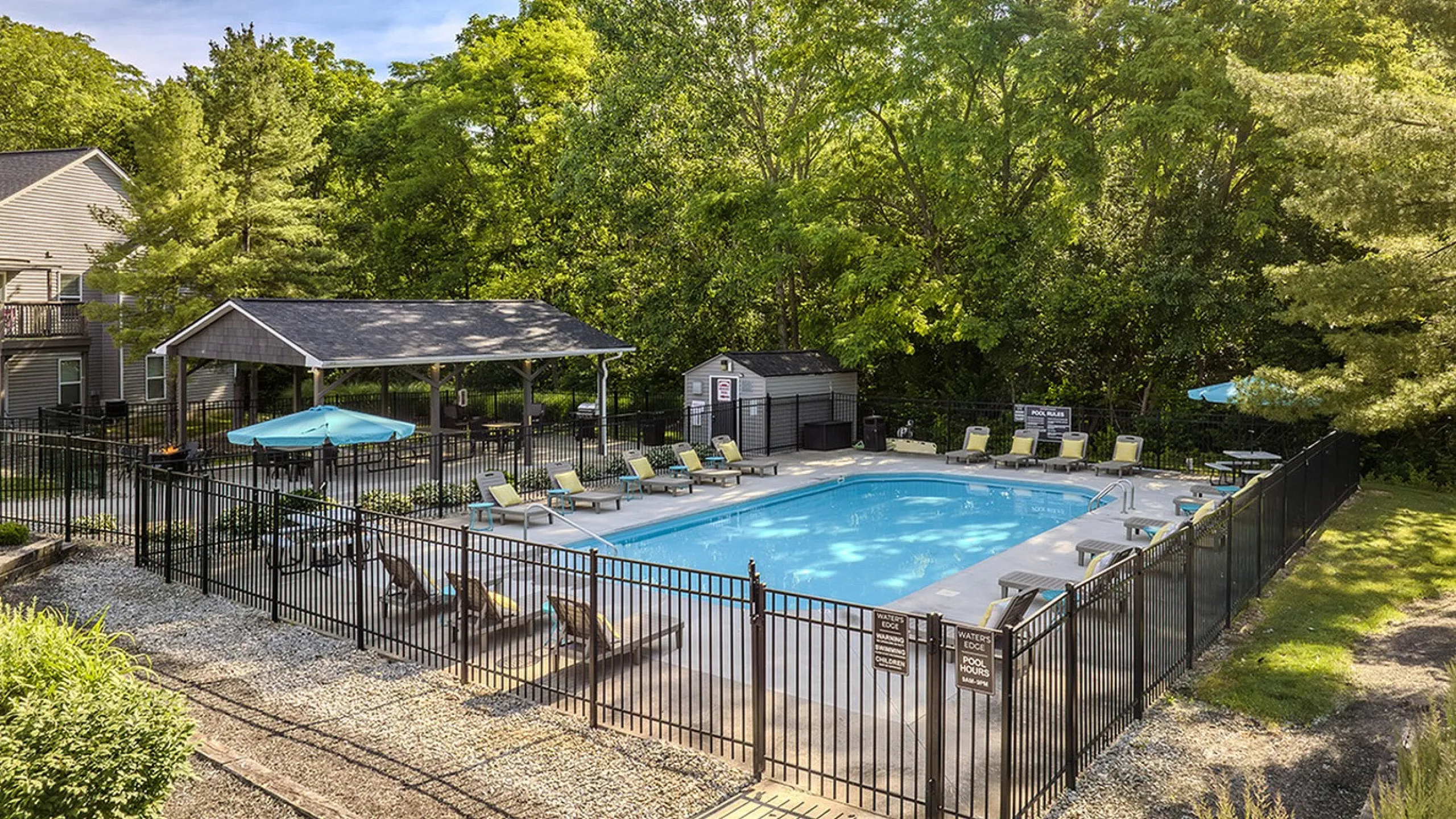 Inviting outdoor pool area surrounded by lush greenery and comfortable lounge chairs, perfect for relaxation and leisure.