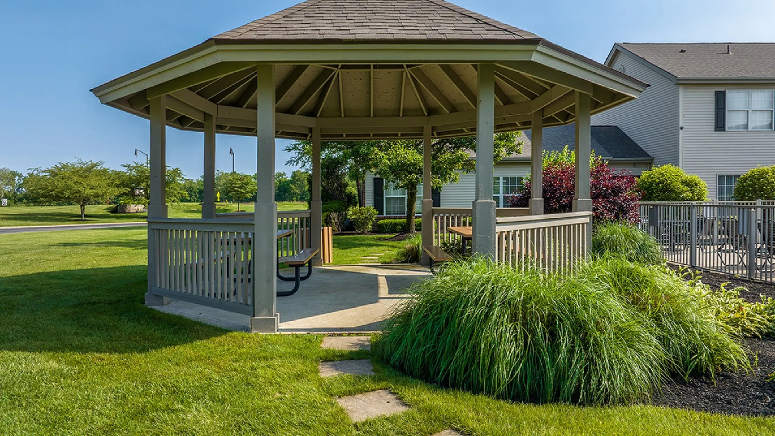 Charming gazebo nestled in lush greenery, perfect for relaxation and outdoor enjoyment in a serene community setting.