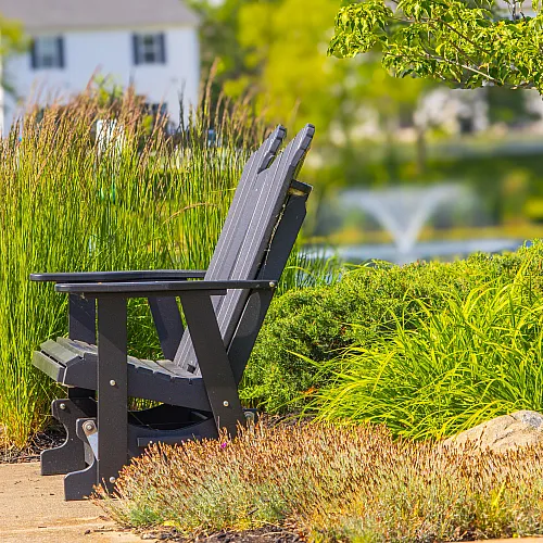 Serene garden view with a cozy bench surrounded by lush greenery and a tranquil fountain in the distance.