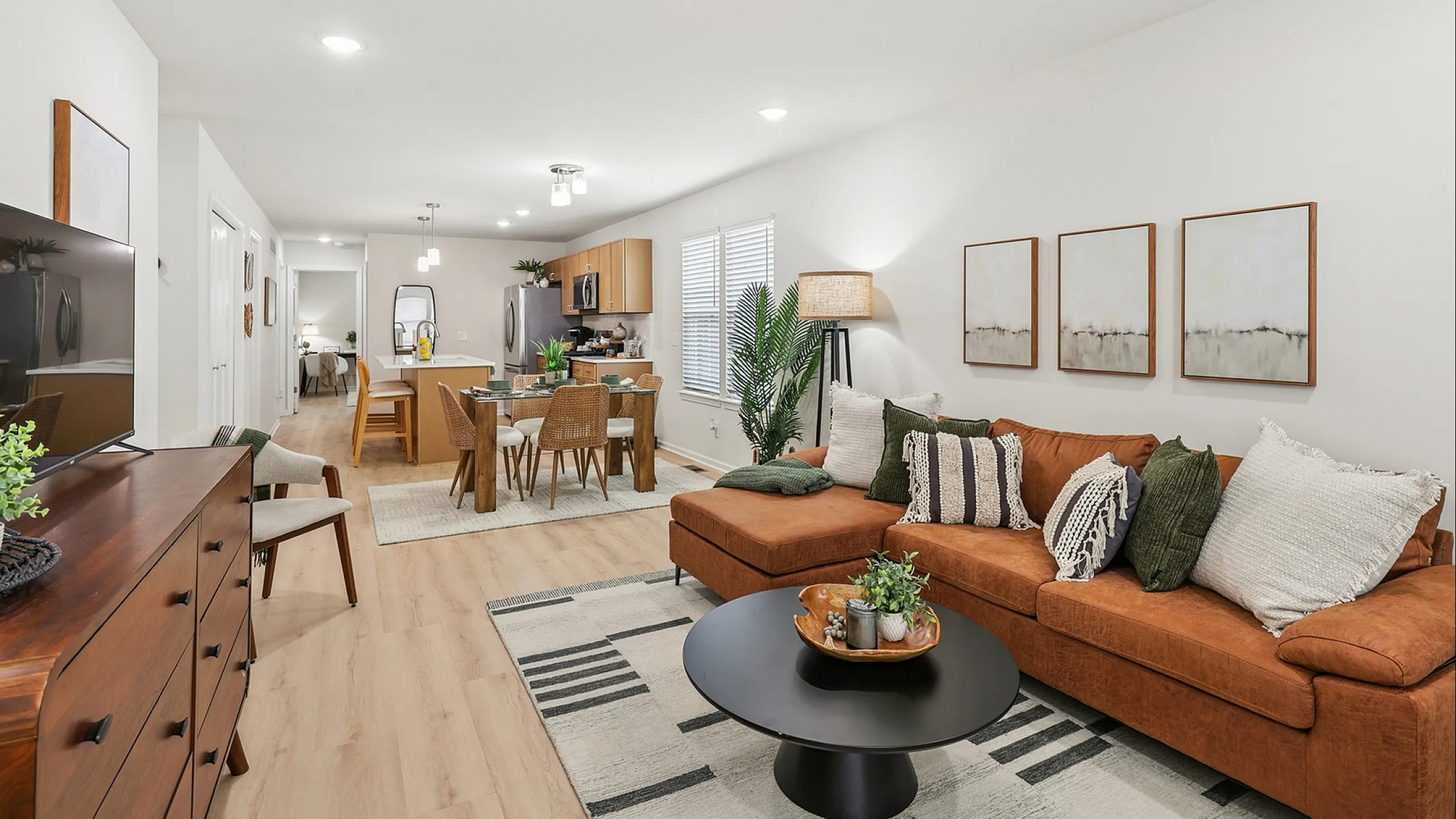 Bright open-concept living space with modern furnishings, warm earth tones, and a cozy ambiance perfect for relaxation and entertaining.