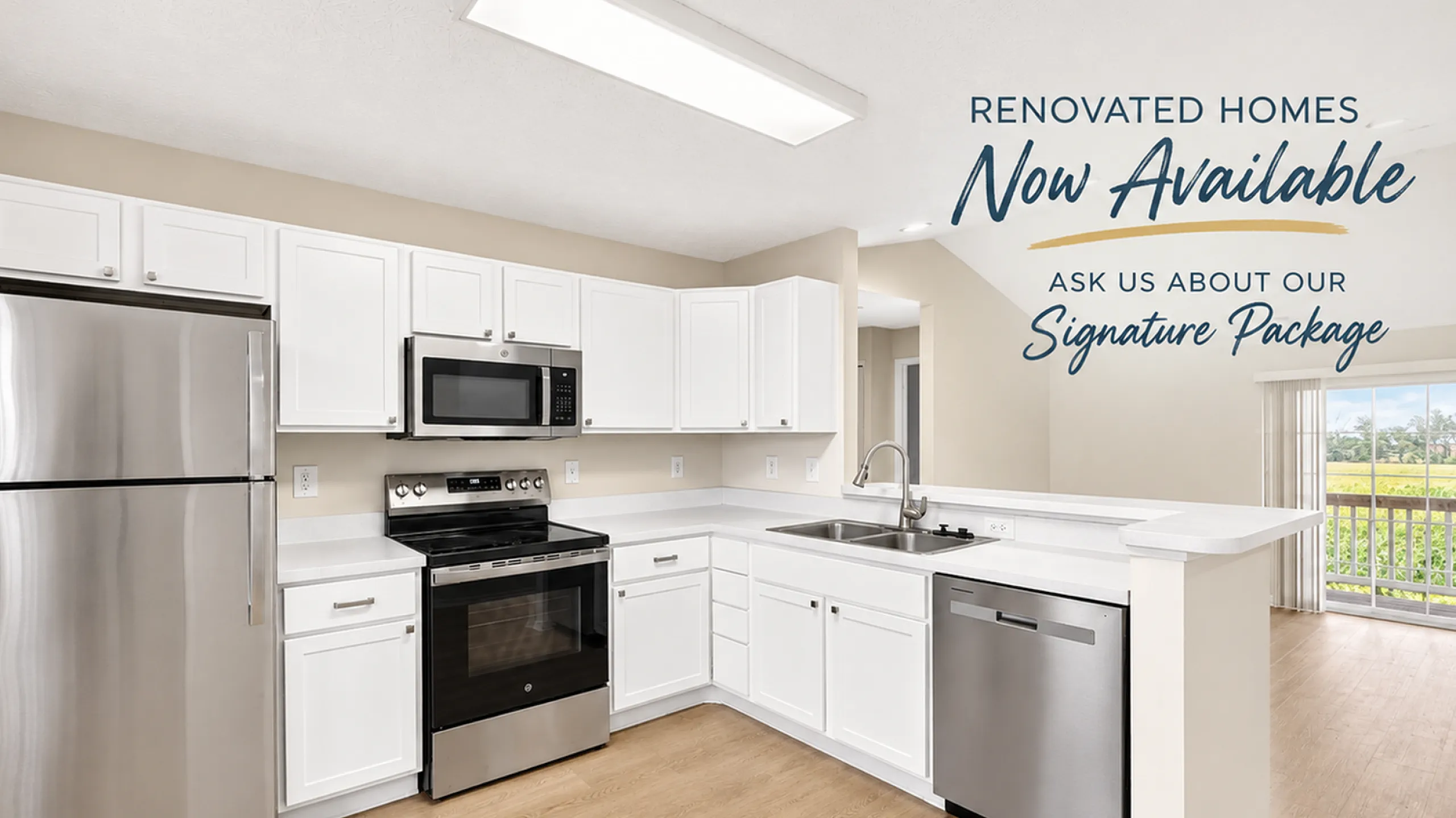 Modern renovated kitchen with stainless steel appliances, sleek white cabinetry, and a bright, open-concept design overlooking a serene outdoor view.