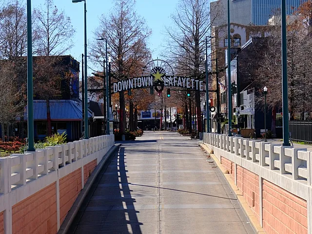 Downtown Lafayette | Charming walkway leading to the vibrant and welcoming Downtown Lafayette, surrounded by lush trees and bustling urban life.