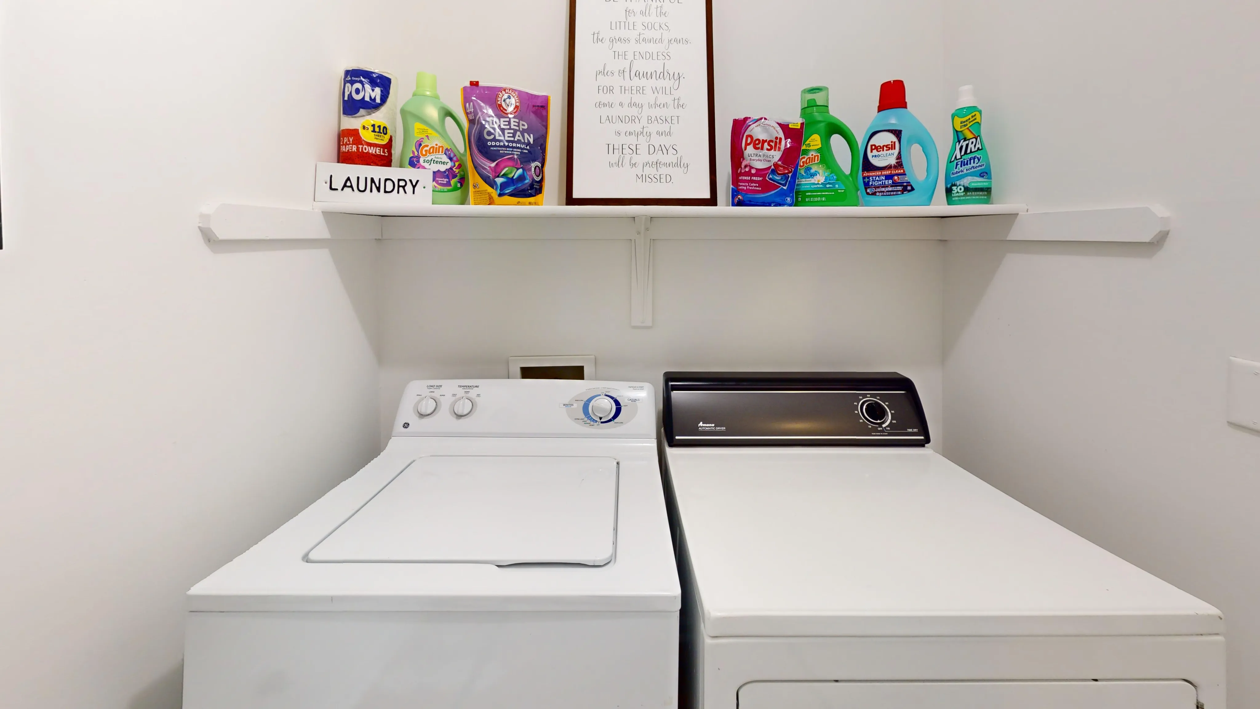 Modern laundry room with efficient washer and dryer, neatly organized detergent shelves for a stylish and functional space.